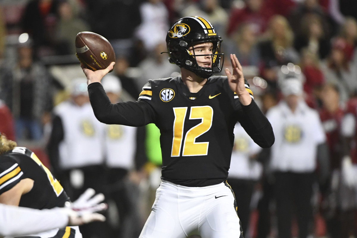 Missouri quarterback Brady Cook (12) throws the ball against Arkansas during an NCAA college football game Friday, Nov. 26, 2021, in Fayetteville, Ark. (AP Photo/Michael Woods)