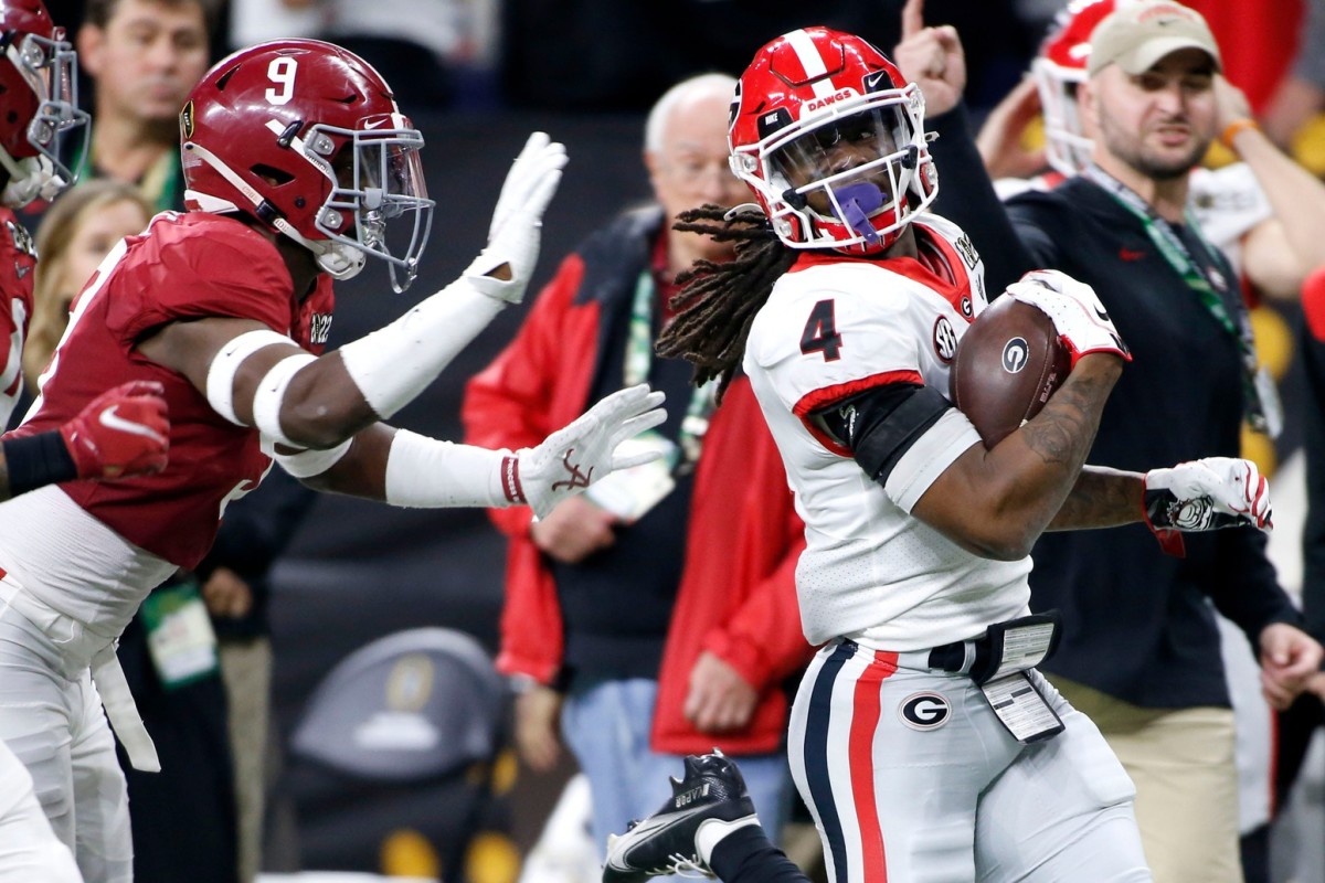 Alabama Crimson Tide defensive back Jordan Battle (9) chases after Alabama Crimson Tide running back Brian Robinson Jr. (4) as he rushes the ball Monday, Jan. 10, 2022, during the College Football Playoff National Championship at Lucas Oil Stadium in Indianapolis.