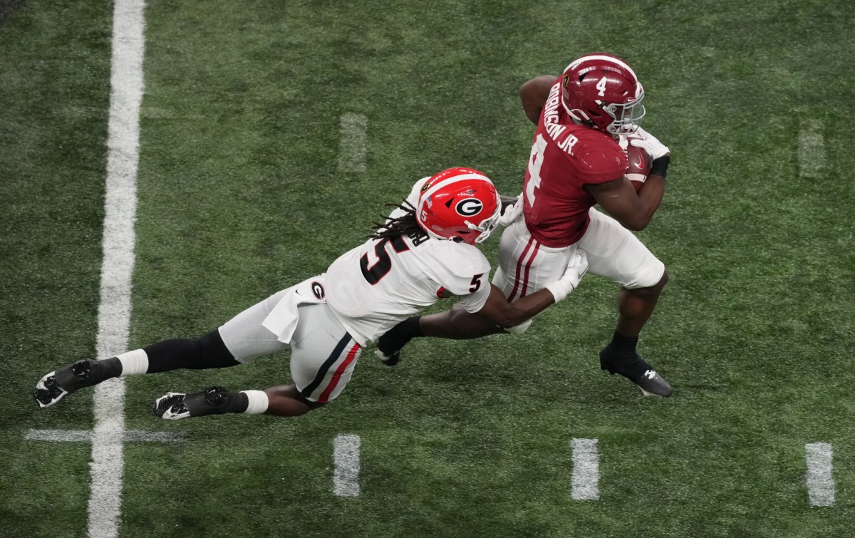 Jan 10, 2022; Indianapolis, IN, USA; Alabama Crimson Tide running back Brian Robinson Jr. (4) runs against Georgia Bulldogs defensive back Kelee Ringo (5) in the third quarter during the 2022 CFP college football national championship game at Lucas Oil Stadium.