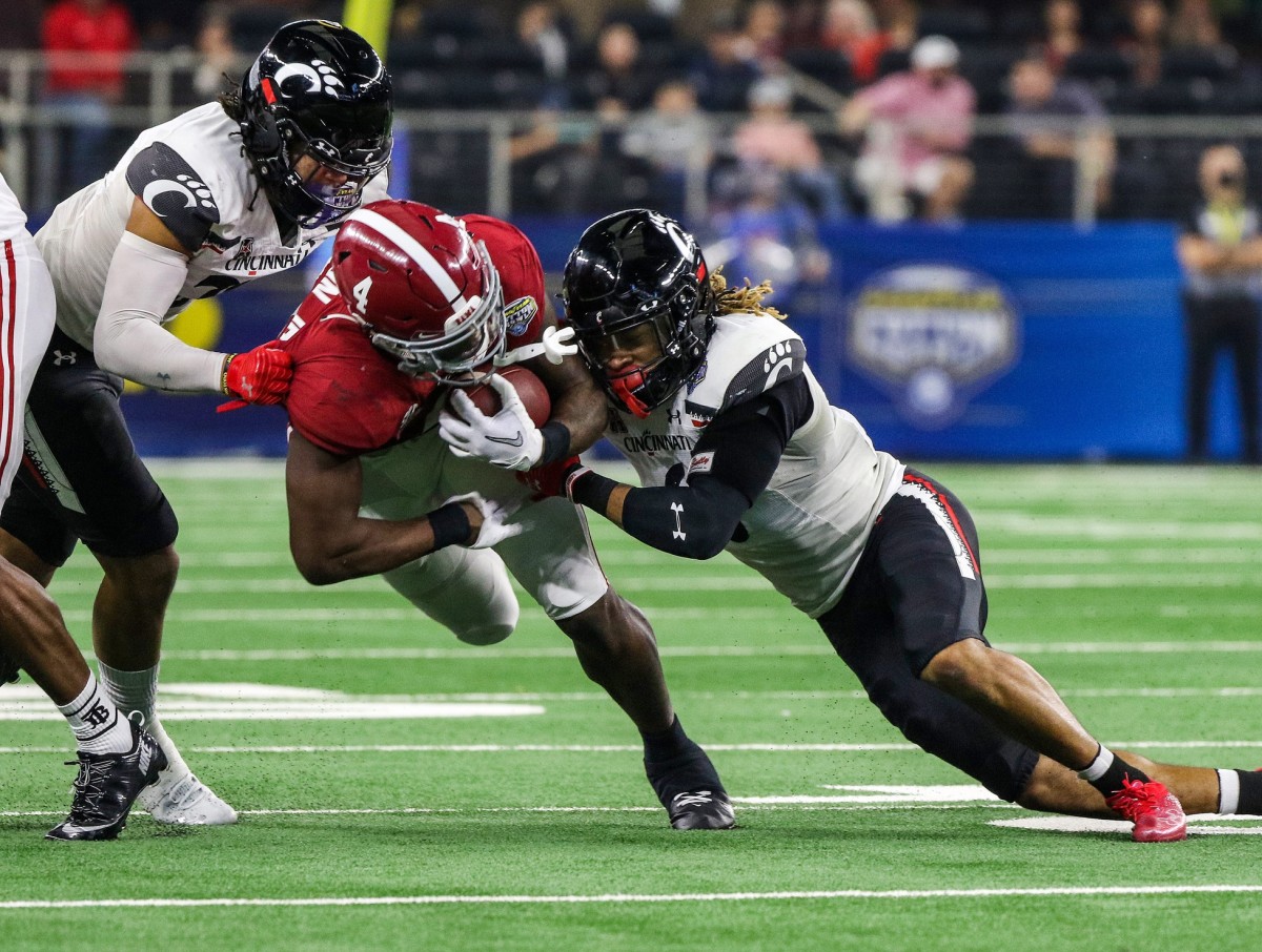 Cincinnati Bearcats linebacker Deshawn Pace (20) left, and safety Bryan Cook (6), right, take down Alabama Crimson Tide running back Brian Robinson Jr. (4) during the College Football Playoff Semifinal at the 86th Cotton Bowl Classic Friday December 31, 2021 at AT & T Stadium in Arlington, Texas.