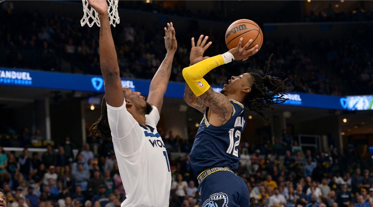 Memphis Grizzlies guard Ja Morant (12) shoots against Minnesota Timberwolves center Naz Reid (11) during the first half during Game 2 of a first-round NBA basketball playoff series Tuesday, April 19, 2022, in Memphis, Tenn.