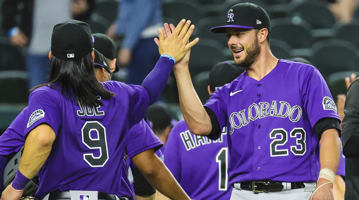Colorado Rockies designated hitter Kris Bryant (23) celebrates with Colorado Rockies left fielder Connor Joe (9) after the game against the Texas Rangers at Globe Life Field.