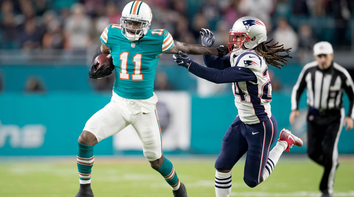 Miami Dolphins wide receiver DeVante Parker (11) stiff arms New England Patriots cornerback Stephon Gilmore (24) on a fourth down and one play in the first quarter at Hard Rock Stadium in Miami Gardens, Florida on December 11, 2017.