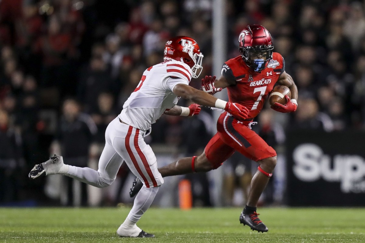 Dec 4, 2021; Cincinnati, Ohio, USA; Cincinnati Bearcats wide receiver Tre Tucker (7) runs with the ball against Houston Cougars cornerback Damarion Williams (6) in the second half during the American Athletic Conference championship game at Nippert Stadium. Mandatory Credit: Katie Stratman-USA TODAY Sports