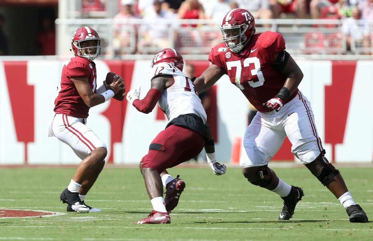 Alabama offensive lineman Evan Neal (73) blocks New Mexico State linebacker Ja'Marvin Hartfield (12) as Alabama quarterback Tua Tagovailoa (13) throws during the first half of Alabama's 62-10 victory over New Mexico State in Bryant-Denny Stadium Saturday, Sep. 7, 2019