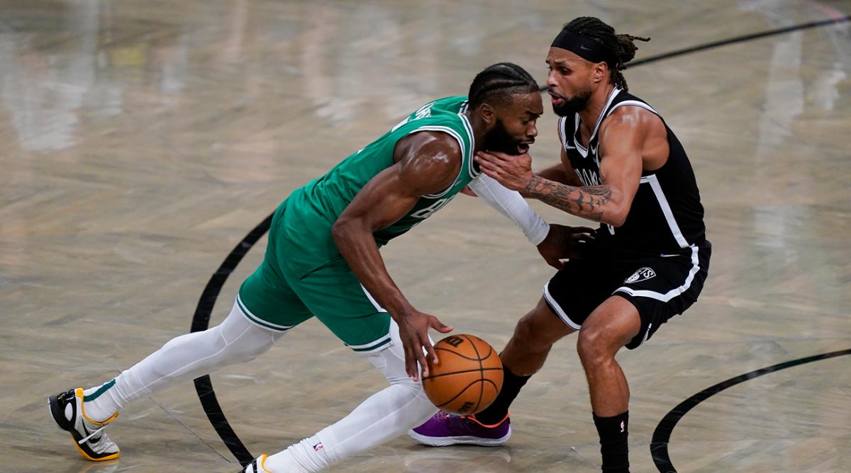 Boston Celtics guard Jaylen Brown, left, drives against Brooklyn Nets guard Patty Mills, right, during the second half of Game 3 of an NBA basketball first-round playoff series, Saturday, April 23, 2022, in New York.