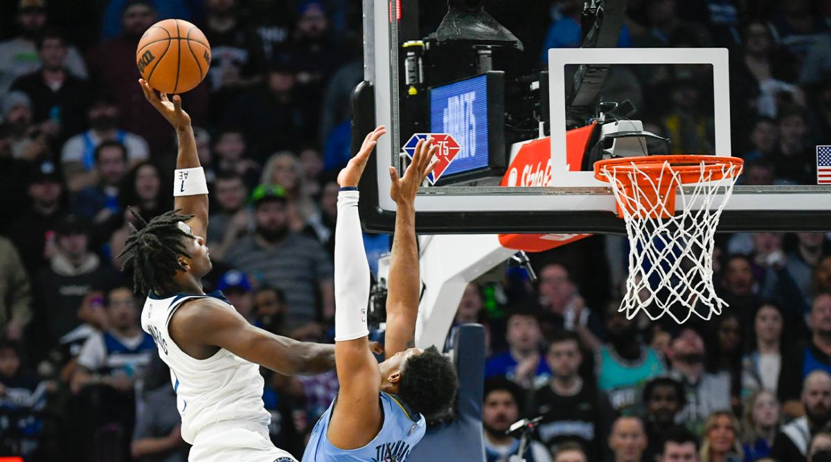 Minnesota Timberwolves guard Anthony Edwards, left, shoots over Memphis Grizzlies forward Xavier Tillman during the first half in Game 4 of an NBA basketball first-round playoff series Saturday, April 23, 2022, in Minneapolis.