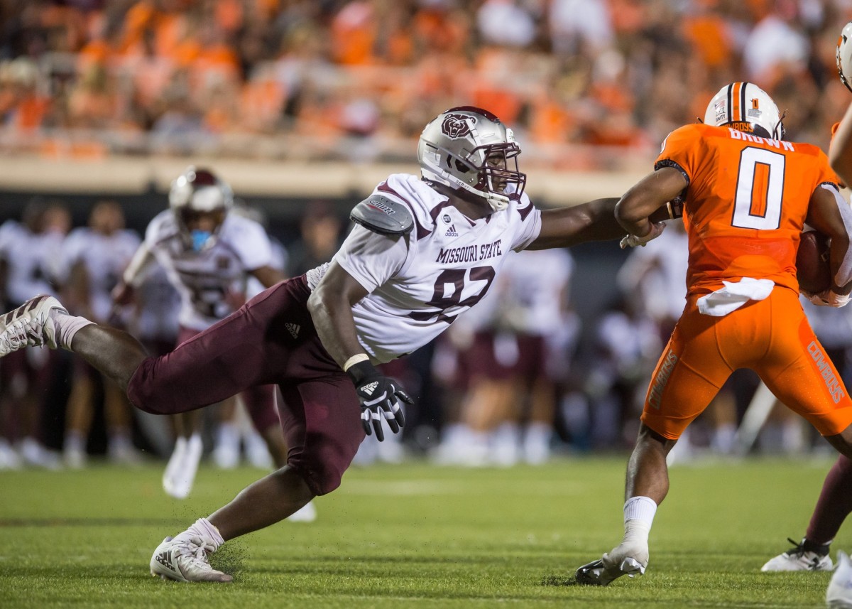 Missouri State Bears defensive lineman Eric Johnson (93) reaches out to try and stop Oklahoma State Cowboys running back LD Brown (0) during the third quarter at Boone Pickens Stadium. Oklahoma State Cowboys beat Missouri State Bears 23-16.