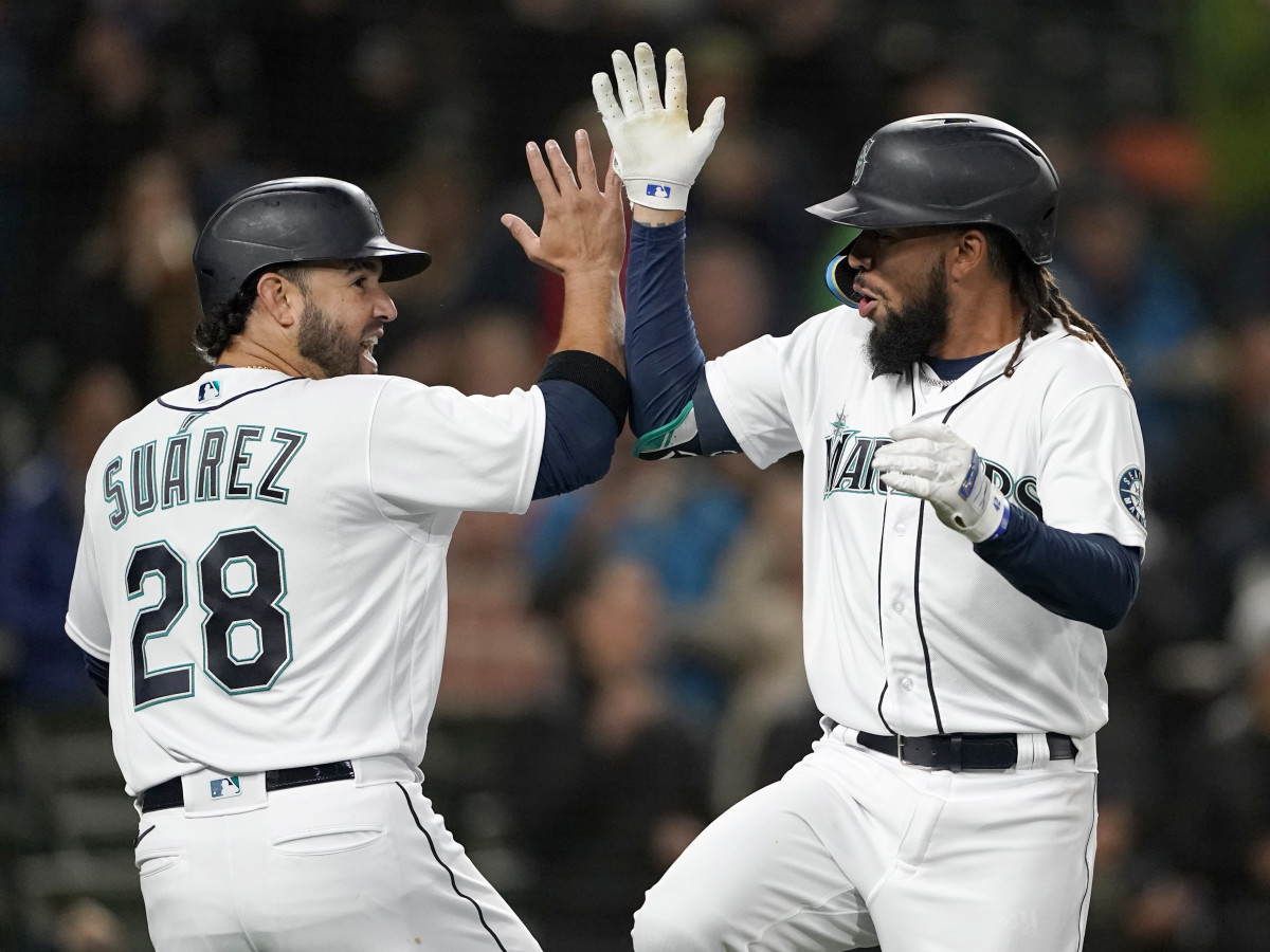 Seattle Mariners’ J.P. Crawford, right, celebrates with Eugenio Suarez (28) at the plate after Crawford hit a three-run home run against the Texas Rangers during the first inning of a baseball game Thursday, April 21, 2022, in Seattle.
