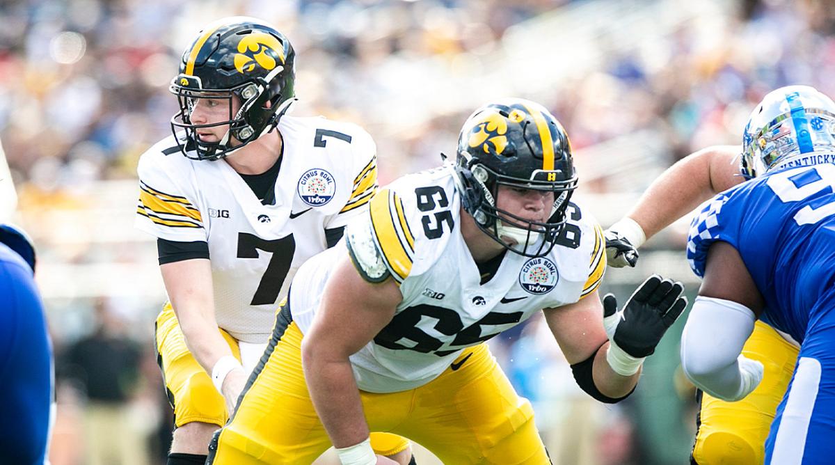 Iowa quarterback Spencer Petras (7) takes a snap from center Tyler Linderbaum (65) during a NCAA college football game in the Vrbo Citrus Bowl against Kentucky, Saturday, Jan. 1, 2022, at Camping World Stadium in Orlando, Fla.
