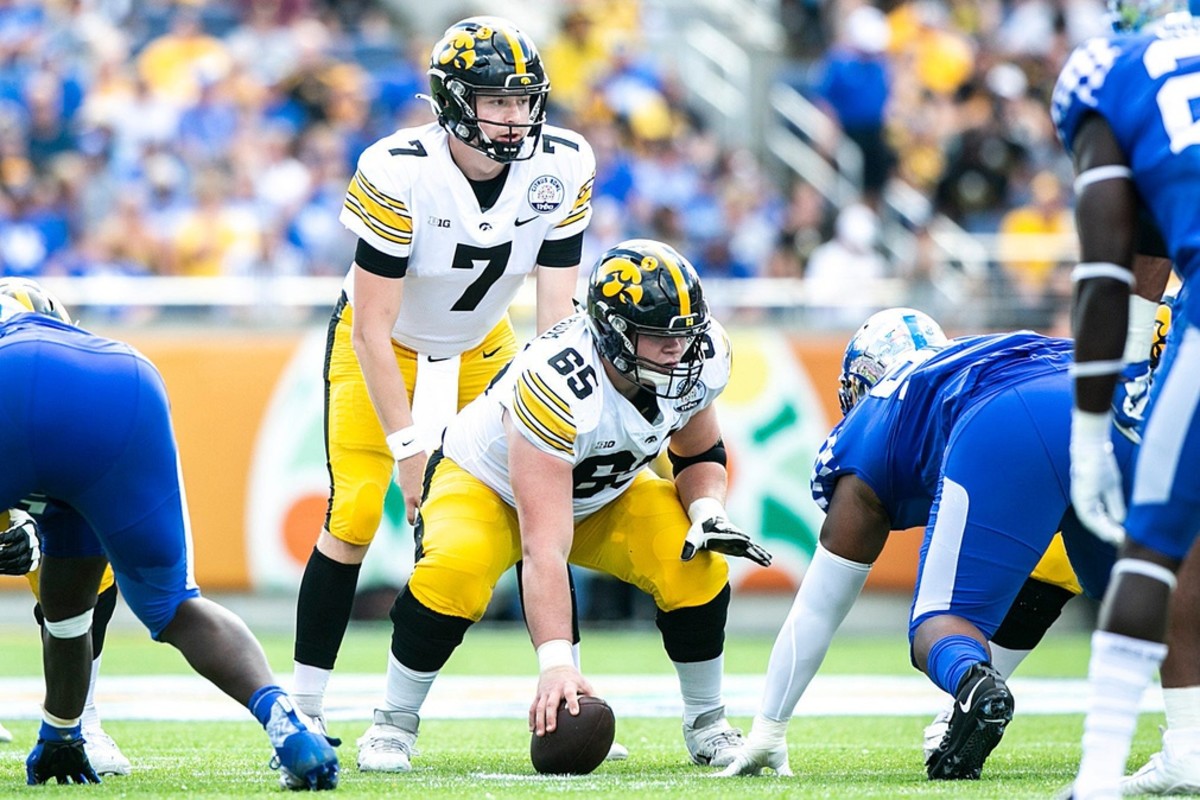Iowa quarterback Spencer Petras (7) gets set to take a snap from center Tyler Linderbaum (65) during an NCAA college football game in the Vrbo Citrus Bowl against Kentucky, Saturday, Jan. 1, 2022, at Camping World Stadium in Orlando, Fla.