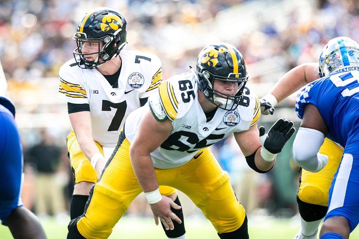 Iowa quarterback Spencer Petras (7) takes a snap from center Tyler Linderbaum (65) during a NCAA college football game in the Vrbo Citrus Bowl against Kentucky, Saturday, Jan. 1, 2022, at Camping World Stadium in Orlando, Fla.
