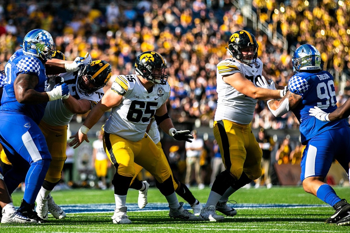 Iowa offensive lineman Connor Colby (77) Tyler Linderbaum (65) and Mason Richman (78) block against Kentucky during a NCAA college football game in the Vrbo Citrus Bowl, Saturday, Jan. 1, 2022, at Camping World Stadium in Orlando, Fla.