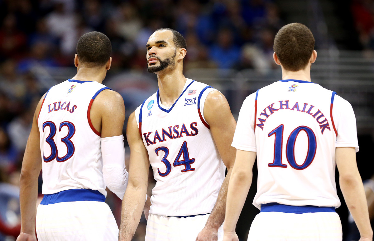 Mar 26, 2016; Louisville, KY, USA; Kansas Jayhawks forward Perry Ellis (34) reacts with forward Landen Lucas (33) and Sviatoslav Mykhailiuk against the Villanova Wildcats during the first half of the south regional final of the NCAA Tournament at KFC YUM!. Mandatory Credit: Aaron Doster-USA TODAY Sports