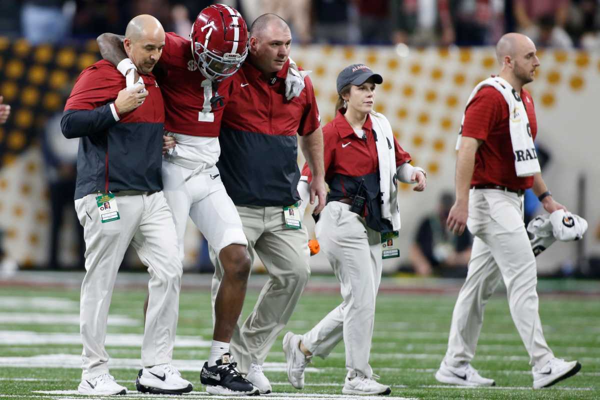 Alabama Crimson Tide wide receiver Jameson Williams (1) is helped off the field after suffering leg injury during the College Football Playoff National Championship against Alabama at Lucas Oil Stadium on Monday, Jan. 10, 2022, in Indianapolis.