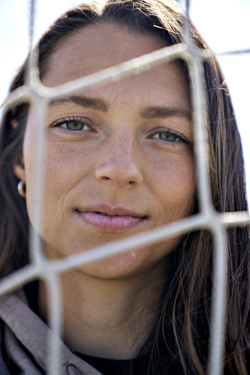 Portrait of Ashley Hatch through a soccer net