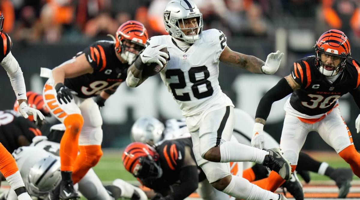 FILE - Las Vegas Raiders’ Josh Jacobs (28) runs during the first half of an NFL wild-card playoff football game against the Cincinnati Bengals, Saturday, Jan. 15, 2022, in Cincinnati. The Las Vegas Raiders are declining the fifth-year options on all three of their 2019 first-round picks as the new regime doesn’t want to commit to players inherited on the roster. General manager Dave Ziegler announced Friday, April 29, 2022, that the team will let defensive end Clelin Ferrell, running back Josh Jacobs and safety Johnathan Abram play out the final year of their rookie contracts instead of extending them through 2023. (AP Photo/AJ Mast, File)