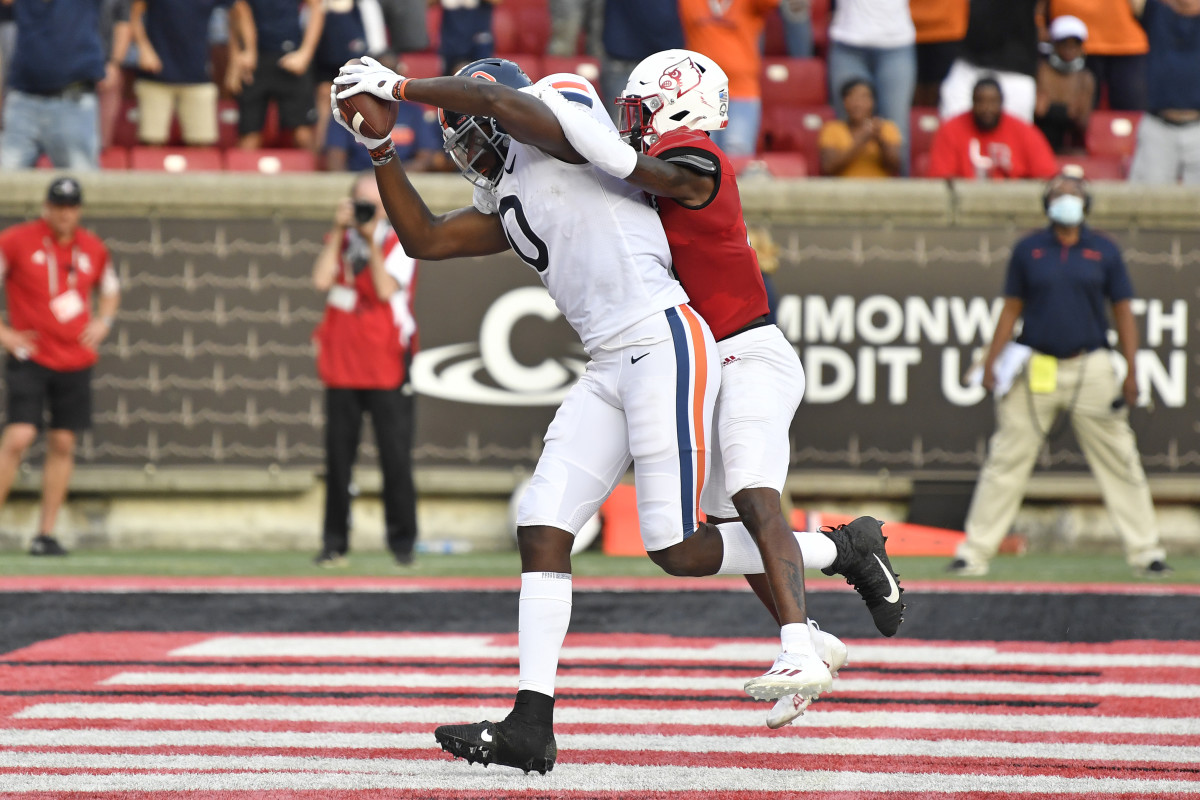 Oct 9, 2021; Louisville, Kentucky, USA; Virginia Cavaliers tight end Jelani Woods (0) pulls in a touchdown pass under the pressure of Louisville Cardinals defensive back Kei'Trel Clark (13) during the second half at Cardinal Stadium. Virginia defeated Louisville 34-33. Mandatory Credit: Jamie Rhodes-USA TODAY Sports