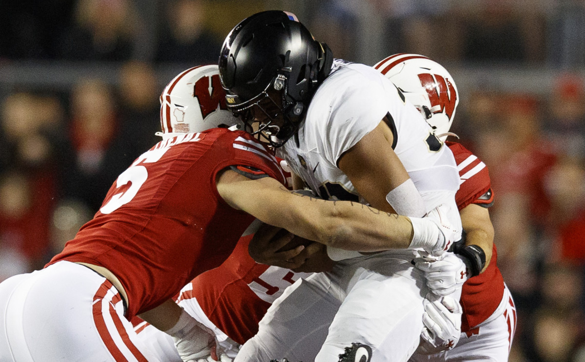 Oct 16, 2021; Madison, Wisconsin, USA; Army Black Knights running back Tyson Riley (32) is tackled by Wisconsin Badgers linebacker Leo Chenal (5) during the first quarter at Camp Randall Stadium. Mandatory Credit: Jeff Hanisch-USA TODAY Sports