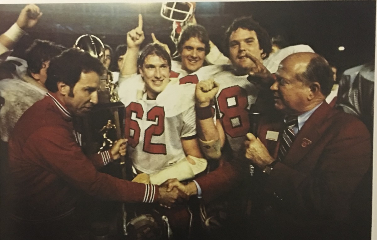 Indiana football wins the Holiday Bowl in 1979 as coach Lee Corso (left) and team captain Terry Tallen (62) accept the trophy.