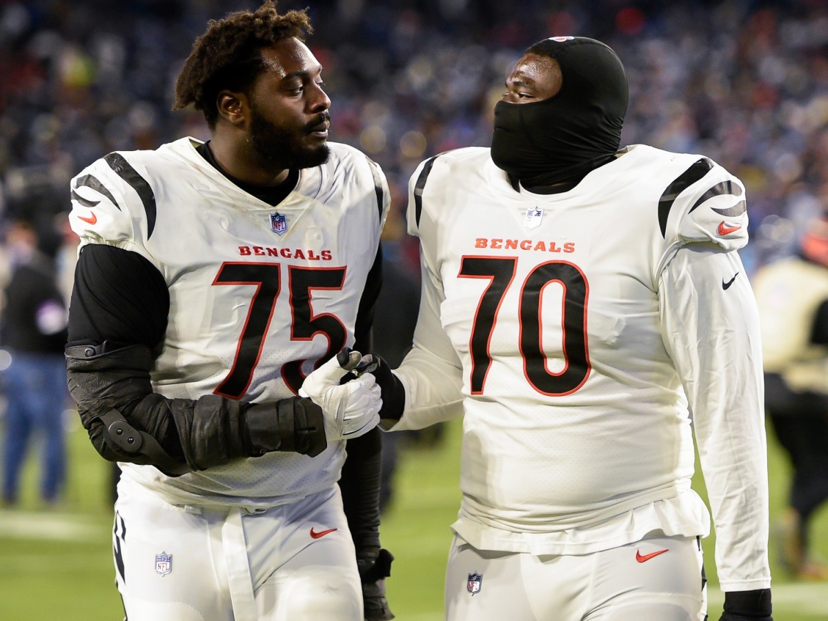 Jan 22, 2022; Nashville, Tennessee, USA; Cincinnati Bengals offensive tackle Isaiah Prince (75) and Cincinnati Bengals offensive tackle D'Ante Smith (70) celebrate the win as they walk of the field against the Tennessee Titans during the second half during a AFC Divisional playoff football game at Nissan Stadium. Mandatory Credit: Steve Roberts-USA TODAY Sports