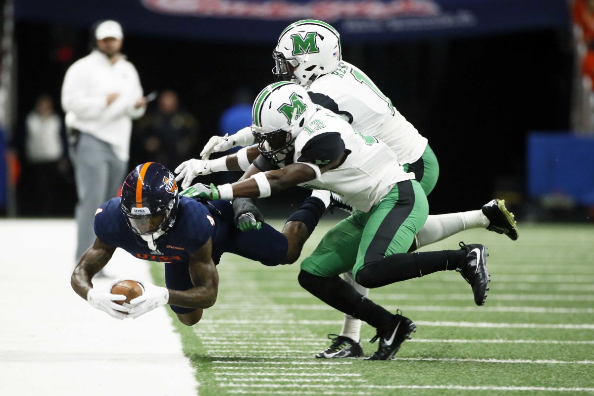 Nov 18, 2017; San Antonio, TX, USA; San Antonio Roadrunners wide receiver Marquez McNair (4) dives for positive yard after a catch as Marshall Thundering Herd safety Nazeeh Johnson (center) and C.J. Reavis (right) defend during the first half at Alamodome. Mandatory Credit: Soobum Im-USA TODAY Sports