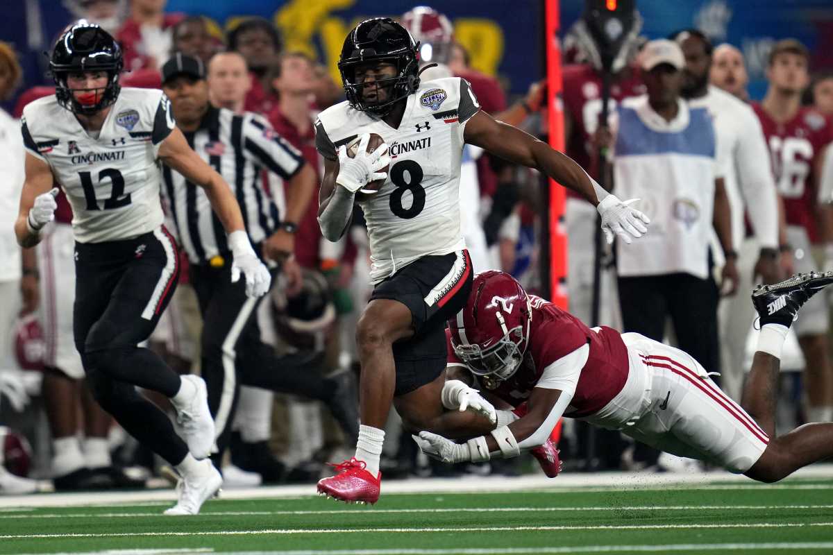 Cincinnati Bearcats wide receiver Michael Young Jr. (8)r uns after a catch as Alabama Crimson Tide defensive back DeMarcco Hellams (2) defends in the first quarter during the College Football Playoff semifinal game at the 86th Cotton Bowl Classic, Friday, Dec. 31, 2021, at AT&T Stadium in Arlington, Texas.