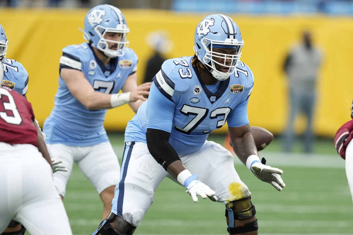 Dec 30, 2021; Charlotte, NC, USA; North Carolina Tar Heels offensive lineman Marcus McKethan (73) back in pass blocking as quarterback Sam Howell (7) takes the snap during the first quarter at Bank of America Stadium.