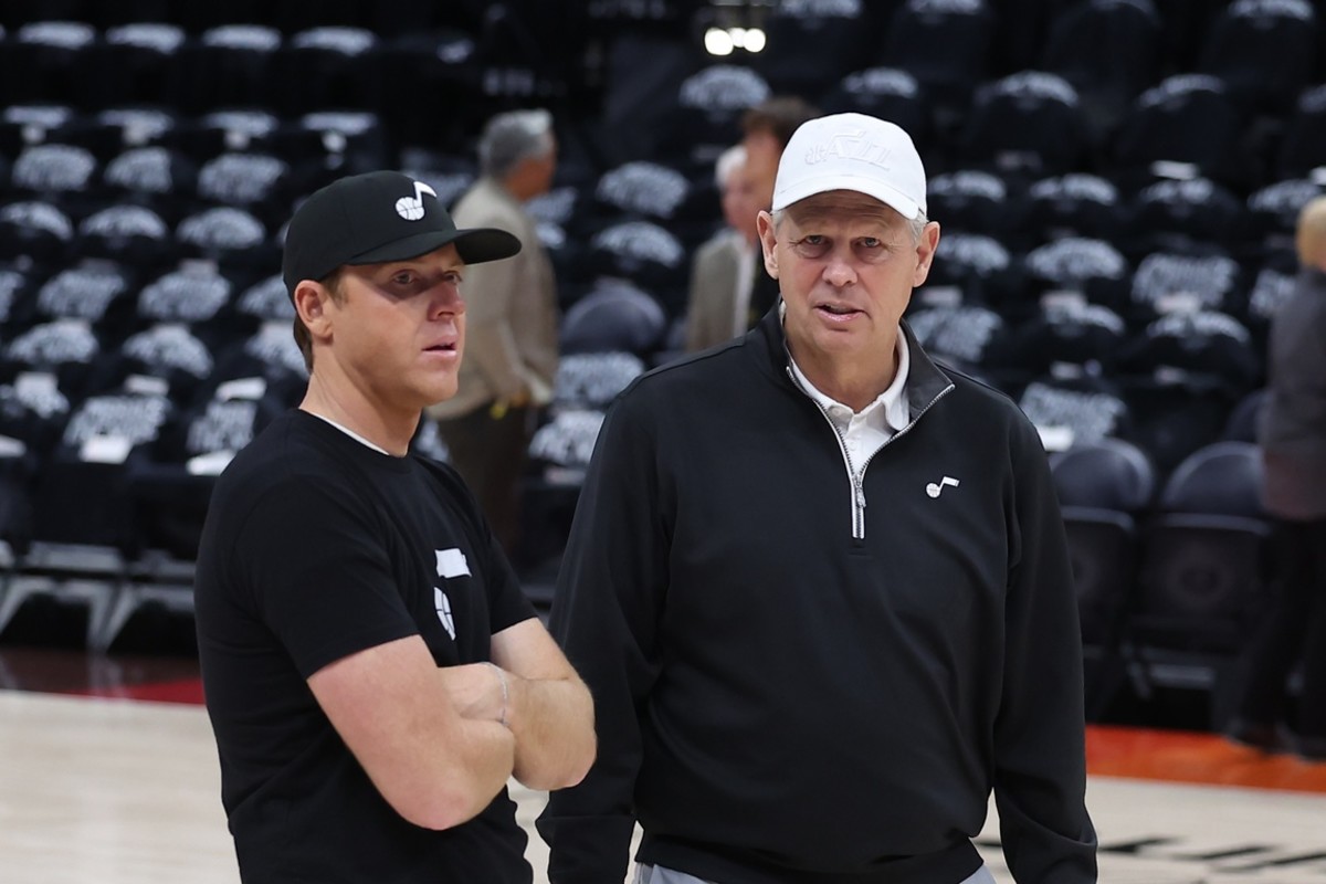 Utah Jazz owner Ryan Smith speaks with Utah Jazz CEO of basketball operations Danny Ainge prior to a game against the Dallas Mavericks during game six of the first round for the 2022 NBA playoffs at Vivint Arena.