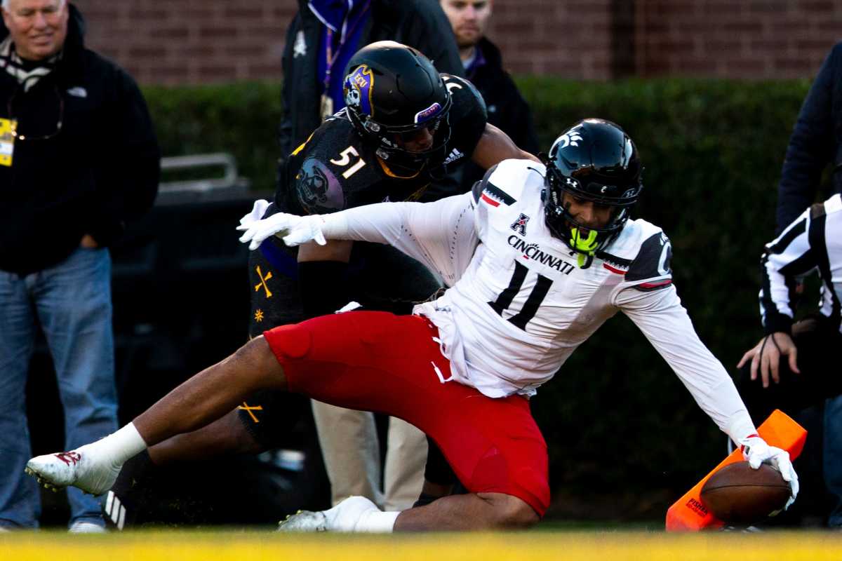 Cincinnati Bearcats tight end Leonard Taylor (11) scores a touchdown as East Carolina Pirates linebacker Aaron Ramseur (51) attempts to stop him in the first half of the NCAA football game between the Cincinnati Bearcats and the East Carolina Pirates at Dowdy-Ficklen Stadium in Greenville, NC, on Friday, Nov. 26, 2021. Cincinnati Bearcats At East Carolina Pirates 09