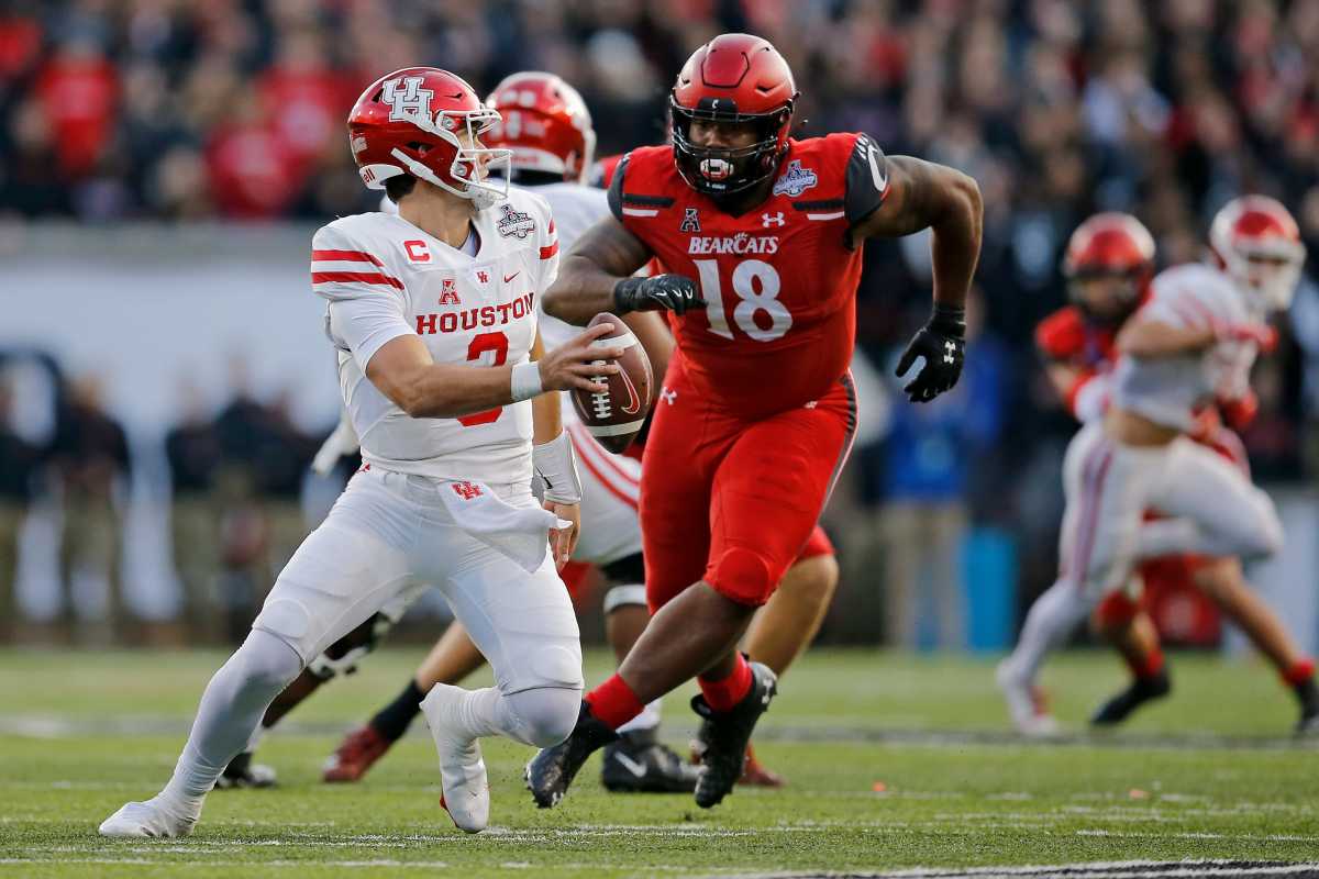 Cincinnati Bearcats defensive lineman Jowon Briggs (18) chases Houston Cougars quarterback Clayton Tune (3) in the first quarter of the American Athletic Conference Championship football game between the Cincinnati Bearcats and the Houston Cougars at Nippert Stadium in Cincinnati on Saturday, Dec. 4, 2021. The Bearcats led 14-13 at the half. Houston Cougars At Cincinnati Bearcats American Athletic Conference Championship