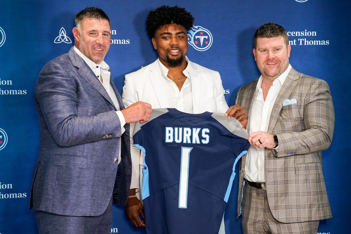 Tennessee Titans first round draft pick wide receiver Treylon Burks, center, holds up his jersey with head coach Mike Wrabel, left, and general manager Jon Robinson, right, during an introductory press conference at Saint Thomas Sports Park in Nashville, Tenn.,