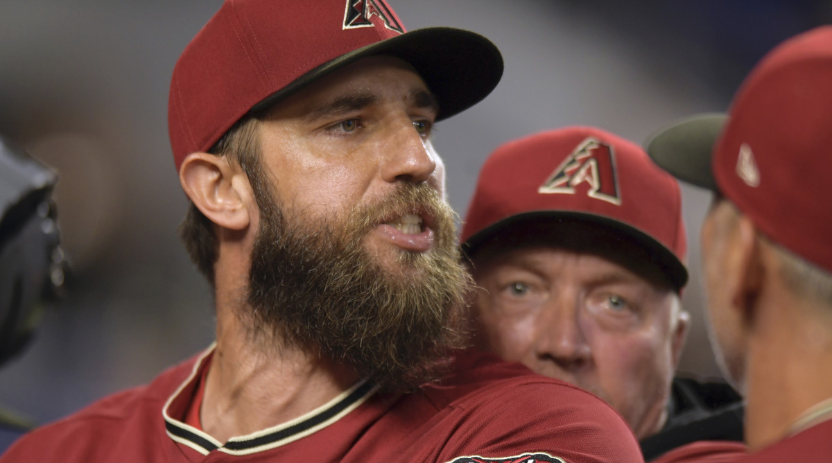 Arizona Diamondbacks’ pitcher Madison Bumgarner is restrained by bench coach Jeff Banister, rear, while arguing with umpires after the first inning of a baseball game against the against the Miami Marlins, Wednesday, May 4, 2022, in Miami.