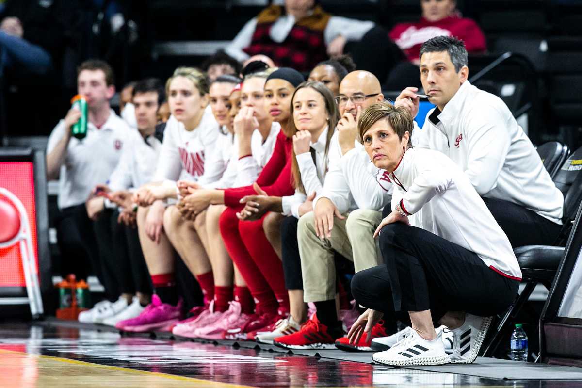 Teri Moren and her bench watch the game from the baseline.