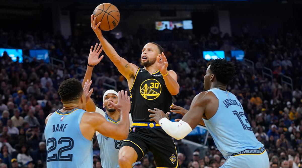 Golden State Warriors guard Stephen Curry (30) shoots between Memphis Grizzlies guard Desmond Bane (22), guard Ziaire Williams, rear, and forward Jaren Jackson Jr. (13) during the first half of Game 3 of an NBA basketball Western Conference playoff semifinal in San Francisco, Saturday, May 7, 2022.