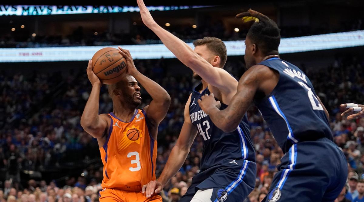Phoenix Suns guard Chris Paul (3) works to pass the ball as Dallas Mavericks forward Maxi Kleber (42) and Reggie Bullock, right, defend in the first half of Game 4 of an NBA basketball second-round playoff series, Sunday, May 8, 2022, in Dallas.