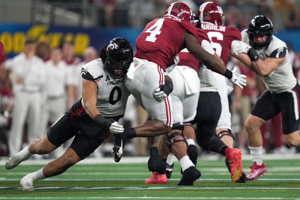 Cincinnati Bearcats linebacker Darrian Beavers (0) tackles Alabama Crimson Tide running back Brian Robinson Jr. (4) for a loss in the first quarter during the College Football Playoff semifinal game at the 86th Cotton Bowl Classic, Friday, Dec. 31, 2021, at AT&T Stadium in Arlington, Texas.