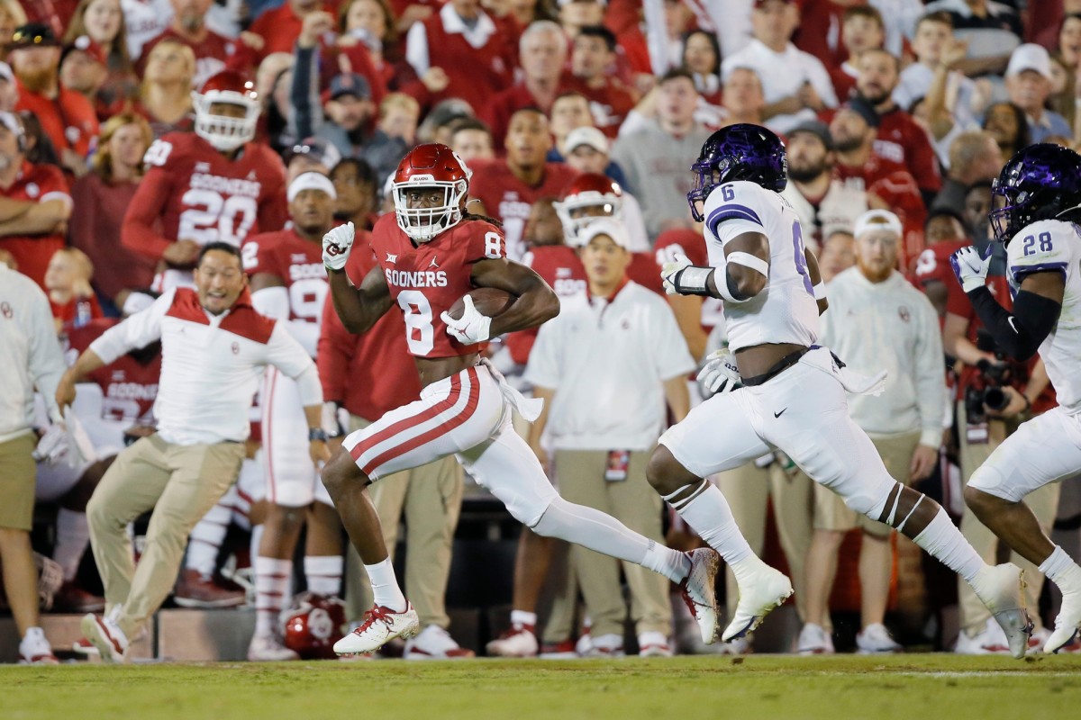 Oklahoma's Michael Woods II (8) runs after a reception past TCU's Jamoi Hodge (6) and Nook Bradford (28) during a college football game between the University of Oklahoma Sooners (OU) and the TCU Horned Frogs at Gaylord Family-Oklahoma Memorial Stadium in Norman, Okla., Saturday, Oct. 16, 2021. Ou Vs Tcu