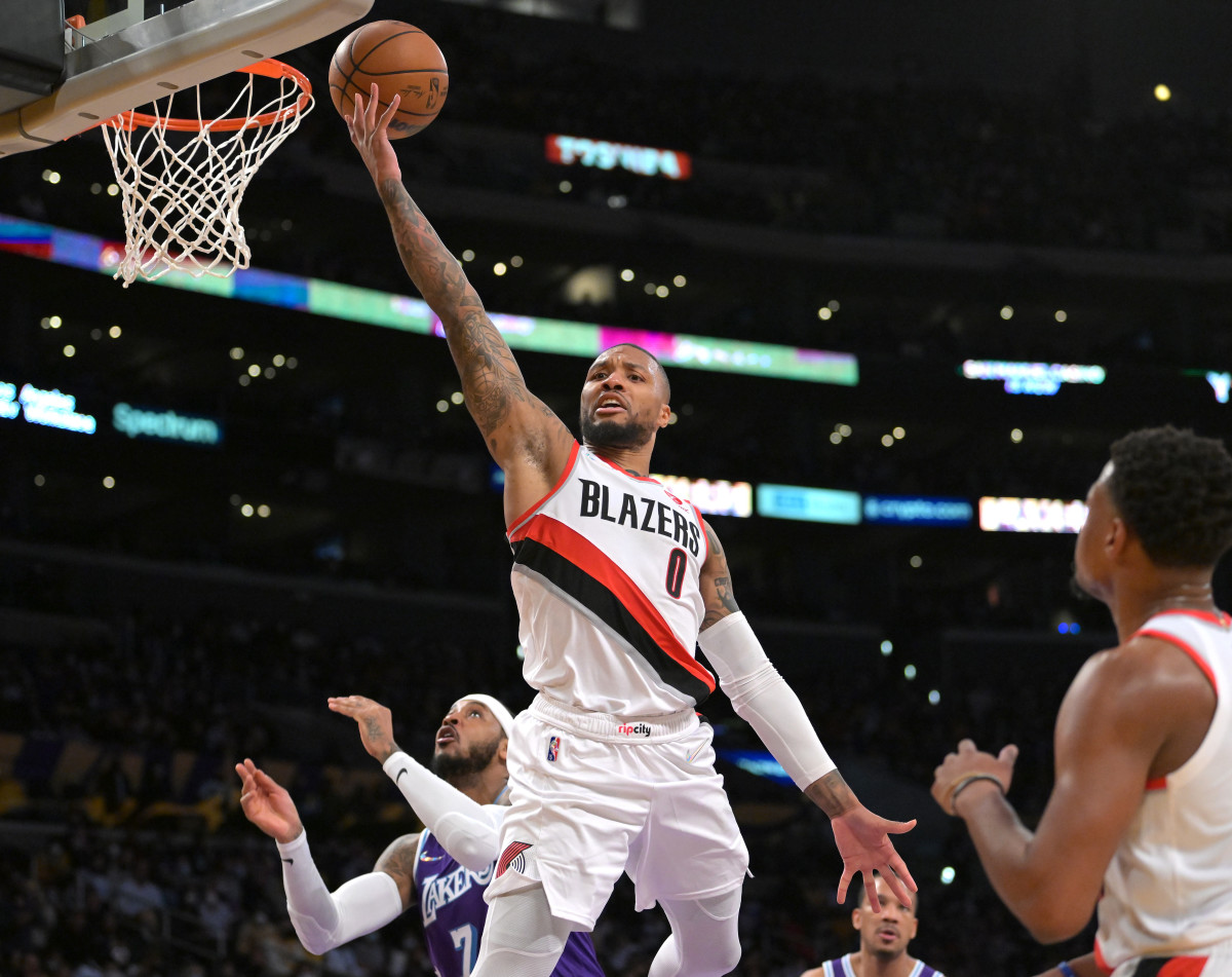 Dec 31, 2021; Los Angeles, California, USA; Portland Trail Blazers guard Damian Lillard (0) goes to the basket past Los Angeles Lakers forward Carmelo Anthony (7) in the first half at Crypto.com Arena. Mandatory Credit: Jayne Kamin-Oncea-USA TODAY Sports