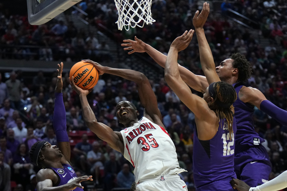 Mar 20, 2022; San Diego, CA, USA; Arizona Wildcats center Christian Koloko (35) shoots against TCU Horned Frogs forward Emanuel Miller (2) and forward Xavier Cork (12) and forward Chuck O'Bannon Jr. (5) in the first half during the second round of the 2022 NCAA Tournament at Viejas Arena. Mandatory Credit: Kirby Lee-USA TODAY Sports