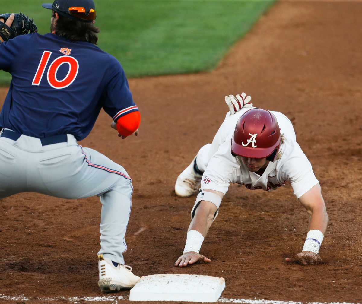 Auburn first baseman Tyler Miller takes a pick off throw too late to catch Alabama base runner Jim Jarvis (10) off base in Sewell-Thomas Stadium Thursday, April 15, 2021