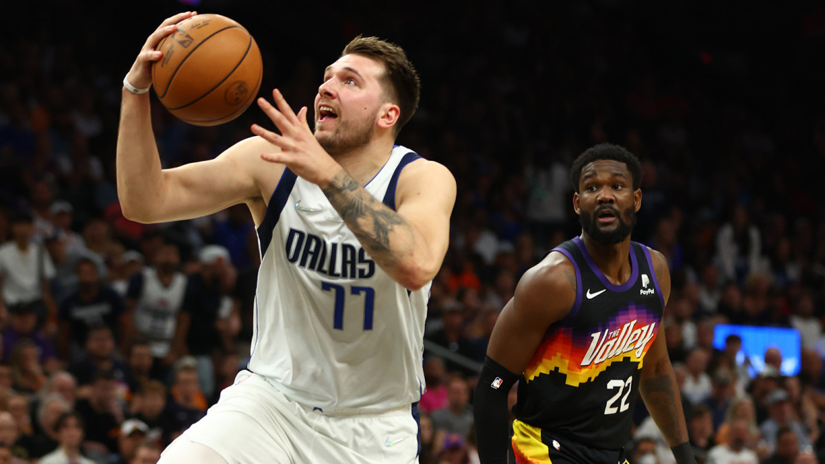 Phoenix Suns center Deandre Ayton (22) looks on as Dallas Mavericks guard Luka Doncic (77) drives to the basket in the first half of game seven of the second round for the 2022 NBA playoffs.
