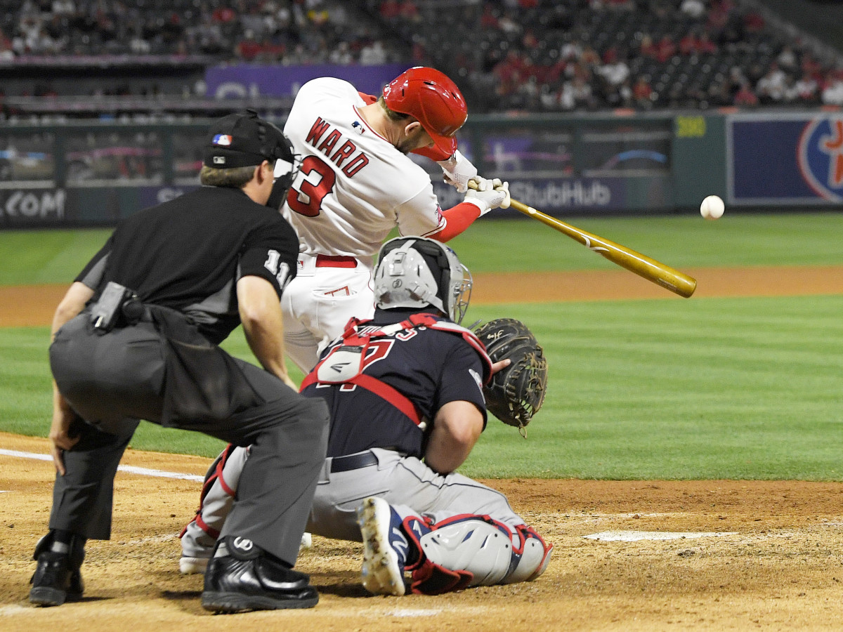 Los Angeles Angels’ Taylor Ward, center, hits a two-run home run as Cleveland Guardians catcher Austin Hedges, right, and home plate umpire Tony Randazzo watch during the seventh inning of a baseball game Monday, April 25, 2022, in Anaheim, Calif.