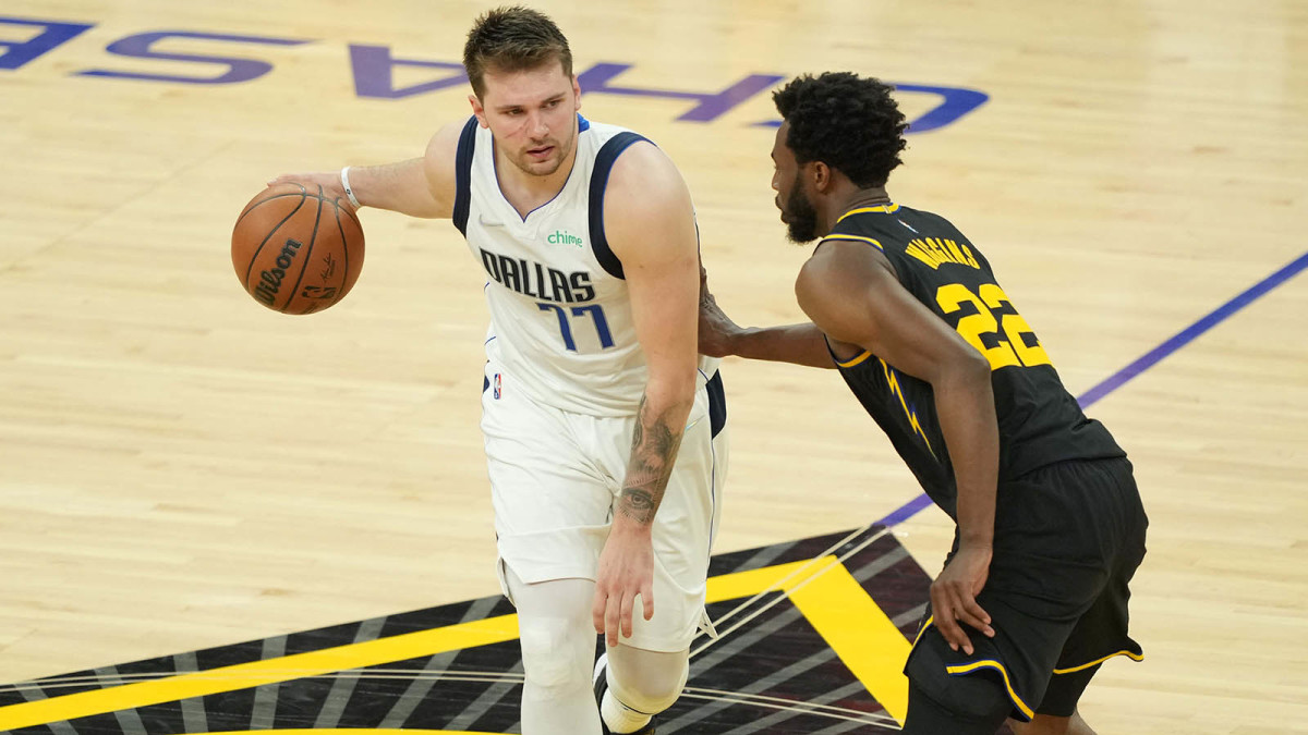 Dallas Mavericks guard Luka Doncic (77) dribbles against Golden State Warriors forward Andrew Wiggins.