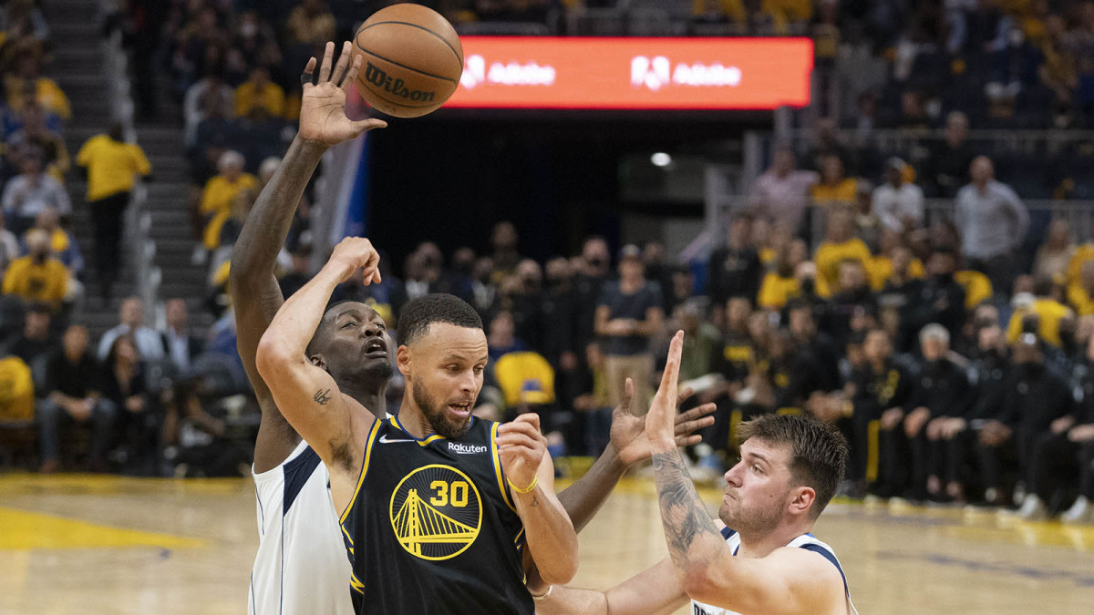 Golden State Warriors guard Stephen Curry (30) passes the basketball against Dallas Mavericks guard Luka Doncic.