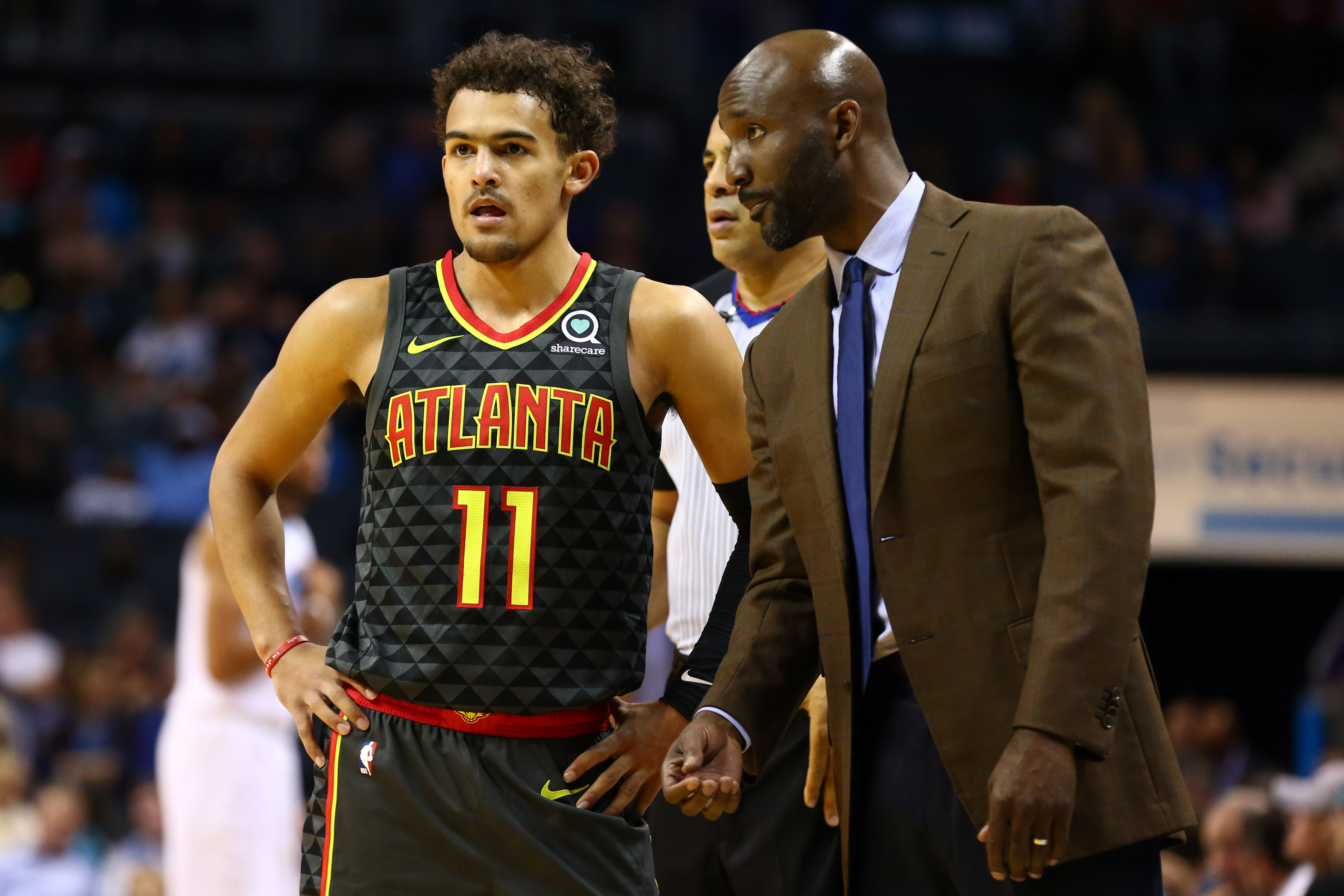 Atlanta Hawks guard Trae Young (11) talks with head coach Lloyd Pierce during the first half against the Charlotte Hornets at Spectrum Center.