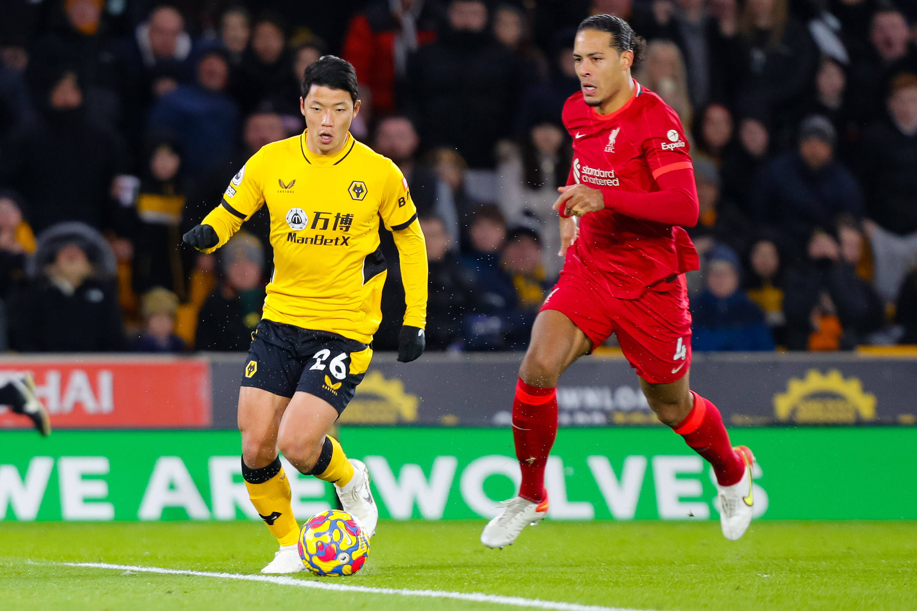 Liverpool defender Virgil van Dijk (right) pictured in pursuit of Wolves forward Hwang Hee-chan during a Premier League game at Molineux in December 2021