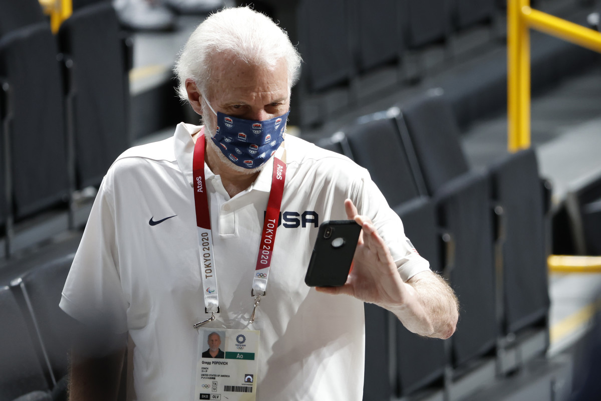 United States head coach Gregg Popovich takes a video of his players walking into the medals ceremony during the Tokyo 2020 Olympic Summer Games at Saitama Super Arena.