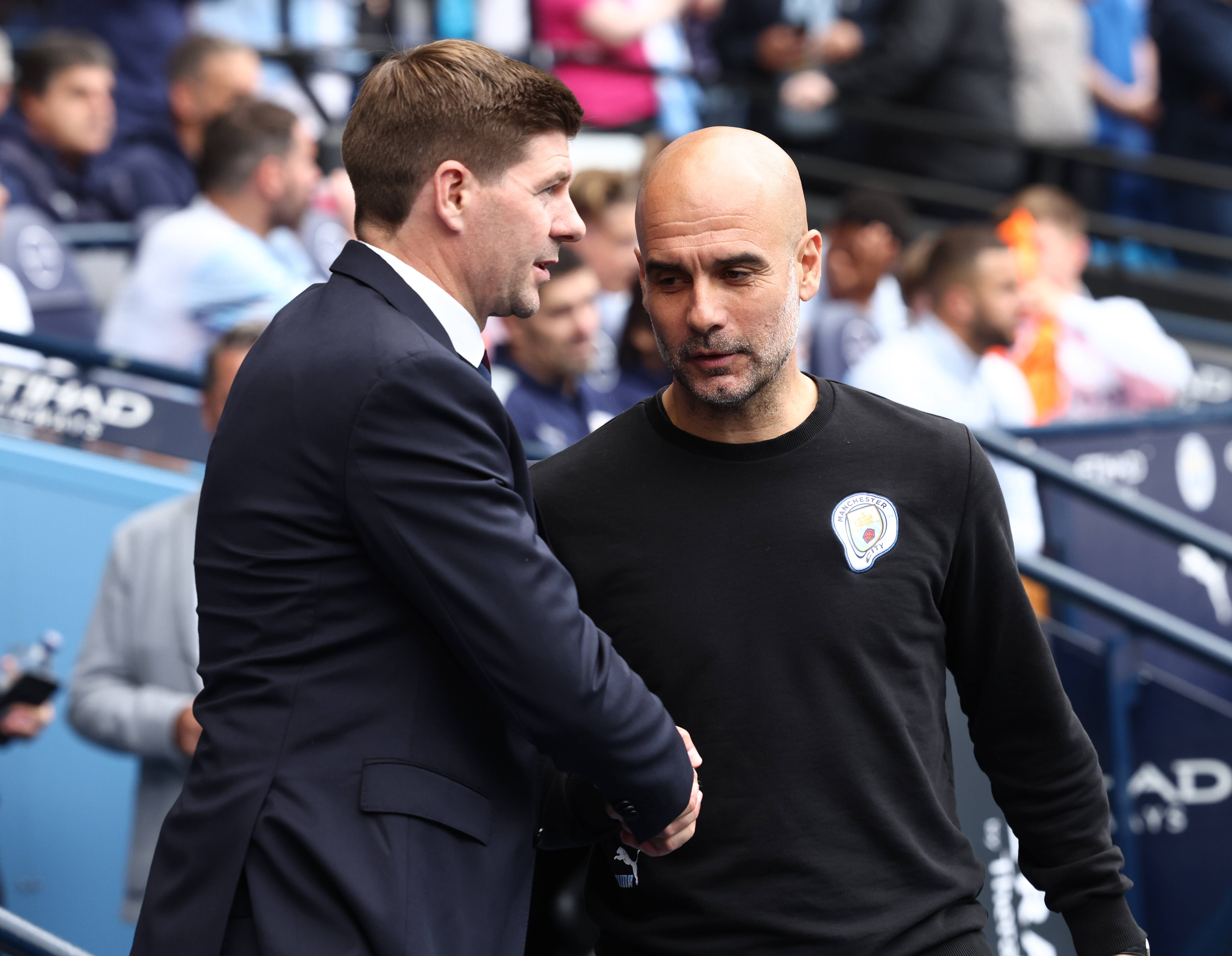 Aston Villa manager Steven Gerrard pictured (left) shaking hands with Manchester City boss Pep Guardiola ahead of their final match in the 2021/22 Premier League season