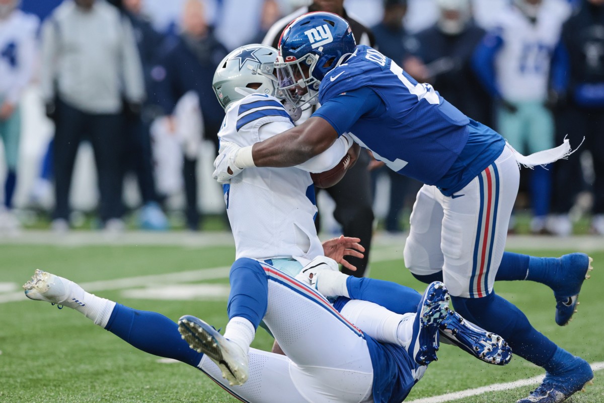 Dec 19, 2021; East Rutherford, New Jersey, USA; New York Giants outside linebacker Azeez Ojulari (51) and outside linebacker Quincy Roche (95) sack Dallas Cowboys quarterback Dak Prescott (4) during the first half at MetLife Stadium.